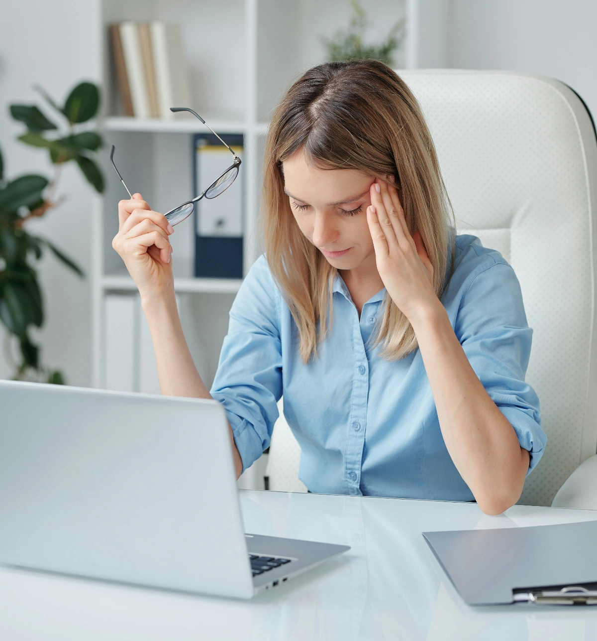 Woman with computer and invoices, smiling